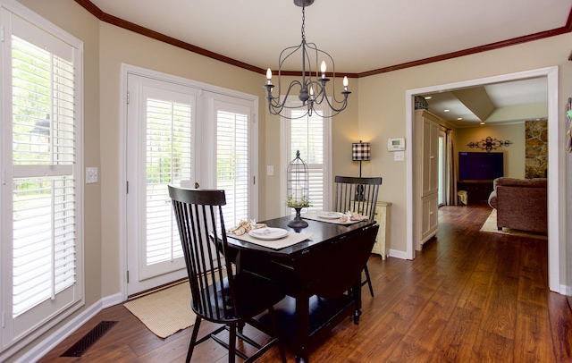 dining room featuring a healthy amount of sunlight, visible vents, dark wood-style flooring, and a notable chandelier