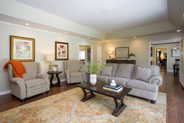 living room featuring baseboards, recessed lighting, a tray ceiling, and wood finished floors