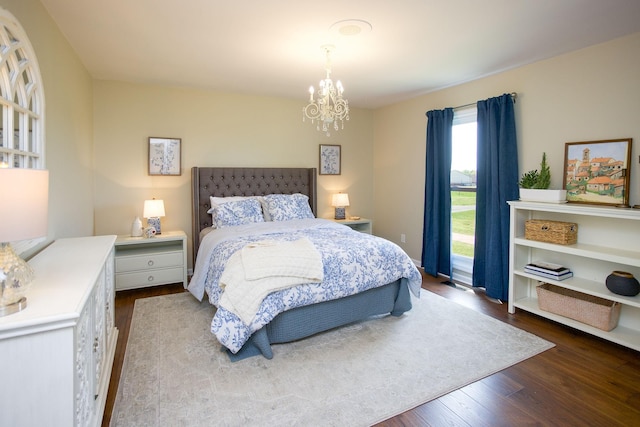 bedroom featuring a chandelier and dark wood finished floors