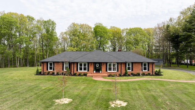 ranch-style home with brick siding, a chimney, and a front lawn