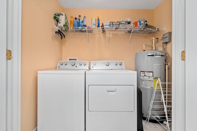 washroom with laundry area, water heater, and independent washer and dryer