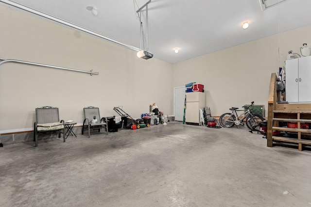 garage with freestanding refrigerator and a garage door opener