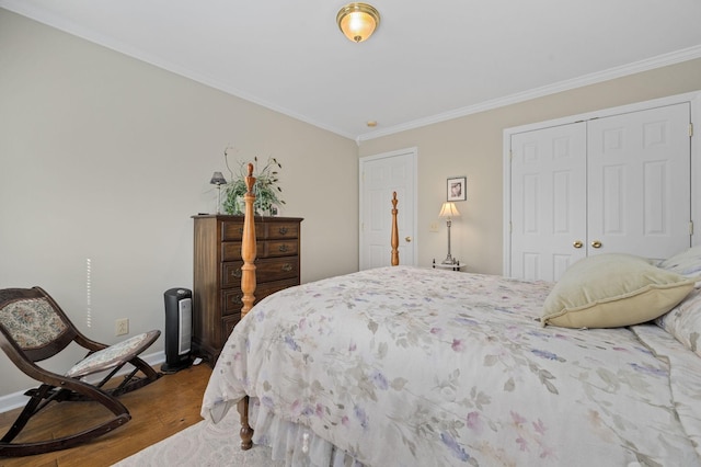 bedroom featuring baseboards, ornamental molding, a closet, and wood finished floors