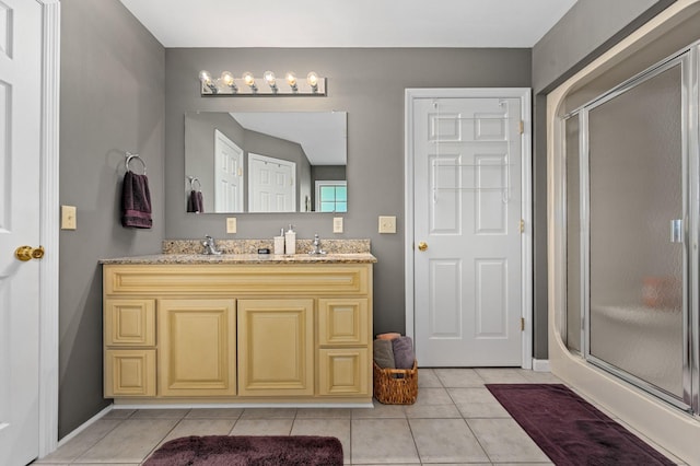 bathroom with vanity, tile patterned floors, baseboards, and a stall shower