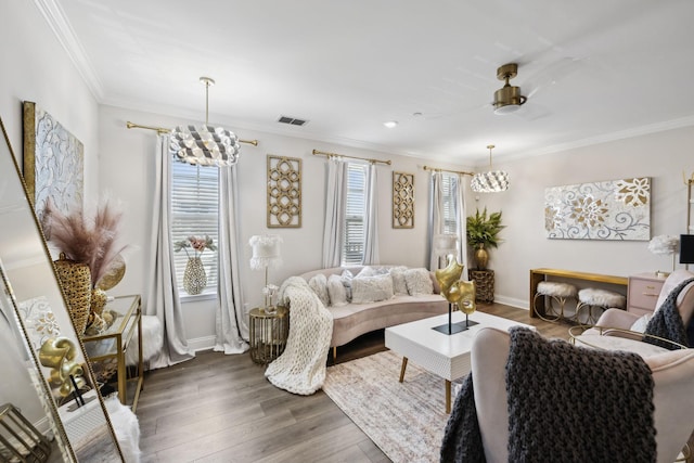 living area featuring crown molding, ceiling fan, baseboards, wood finished floors, and visible vents