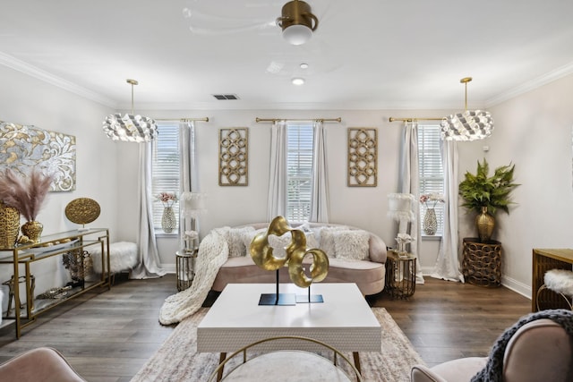 living area featuring baseboards, visible vents, ornamental molding, and wood finished floors