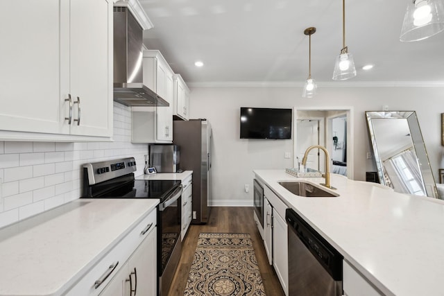kitchen featuring wall chimney range hood, white cabinets, appliances with stainless steel finishes, a sink, and decorative backsplash