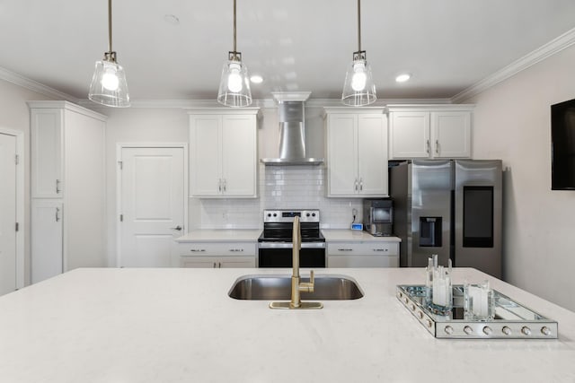 kitchen featuring wall chimney range hood, appliances with stainless steel finishes, ornamental molding, and decorative light fixtures