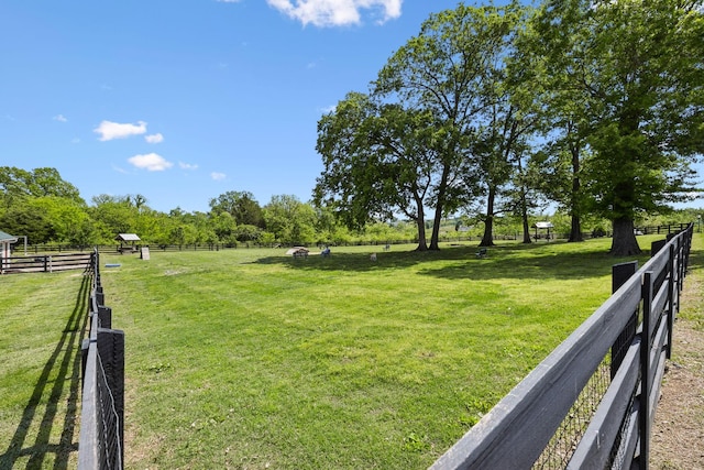 view of yard featuring fence and a rural view