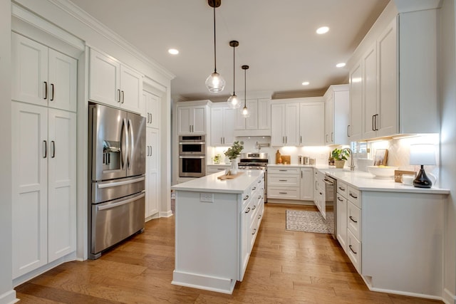 kitchen with light countertops, appliances with stainless steel finishes, white cabinets, and light wood finished floors