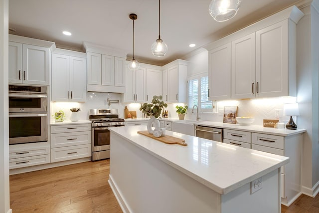 kitchen featuring decorative backsplash, a center island, a sink, white cabinets, and stainless steel appliances