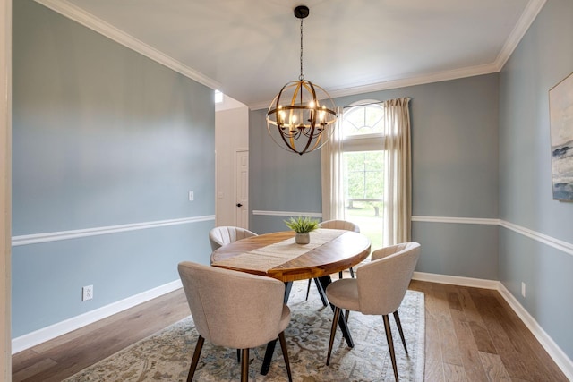 dining space with baseboards, an inviting chandelier, ornamental molding, and wood finished floors