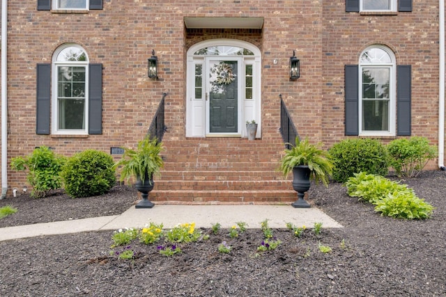 doorway to property with brick siding