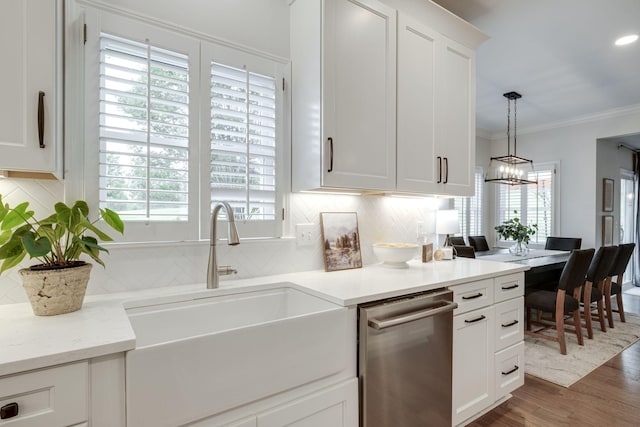 kitchen with wood finished floors, a sink, dishwasher, and a healthy amount of sunlight