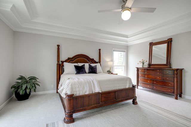 bedroom featuring light colored carpet, a raised ceiling, and crown molding