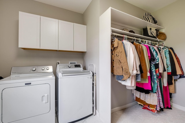 laundry room with cabinet space, baseboards, washing machine and dryer, and light carpet