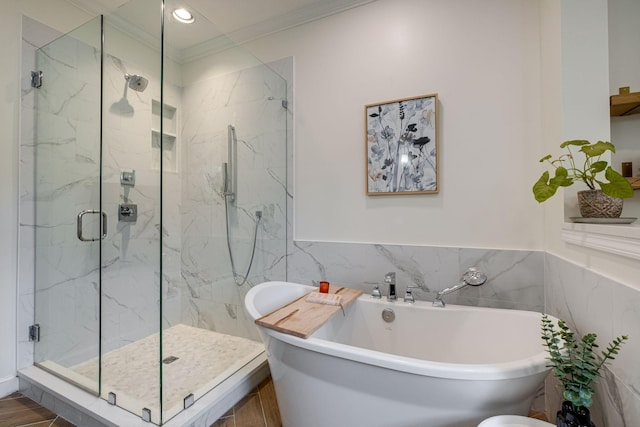 bathroom with a freestanding bath, tile walls, a marble finish shower, ornamental molding, and recessed lighting