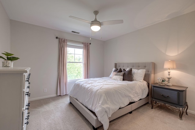 bedroom featuring visible vents, a ceiling fan, baseboards, and light carpet