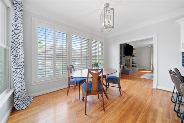 dining room featuring light wood-style floors, ornamental molding, and baseboards