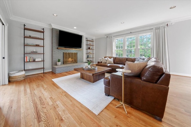 living area featuring ornamental molding, light wood finished floors, built in shelves, and a fireplace
