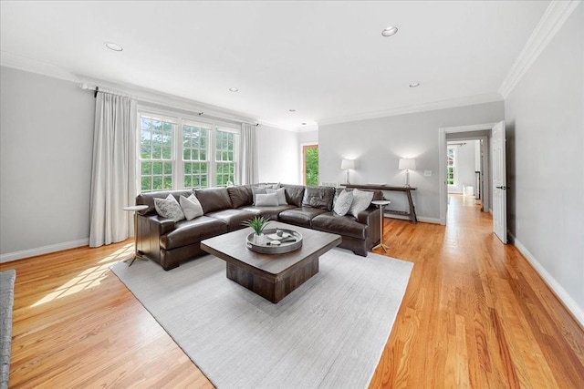 living area featuring baseboards, ornamental molding, and light wood finished floors