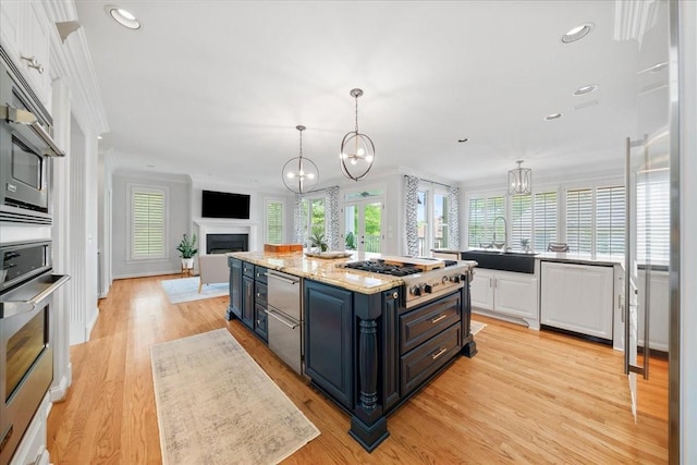 kitchen featuring a sink, plenty of natural light, white cabinetry, and open floor plan