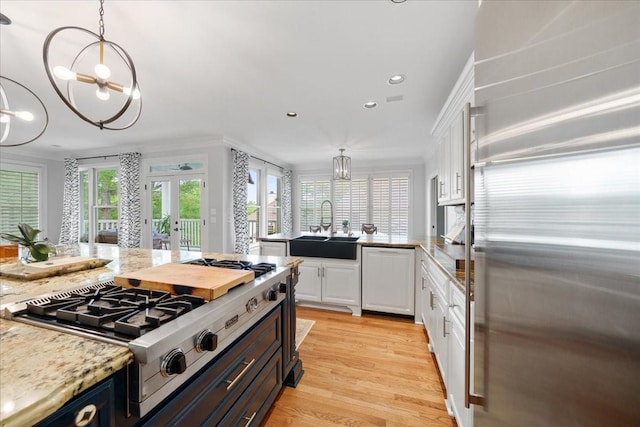 kitchen with a sink, appliances with stainless steel finishes, french doors, and white cabinetry