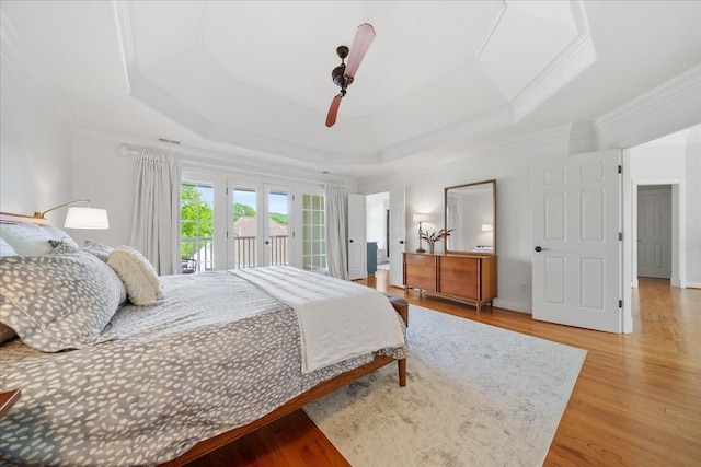 bedroom with visible vents, ornamental molding, access to exterior, light wood-style floors, and a tray ceiling
