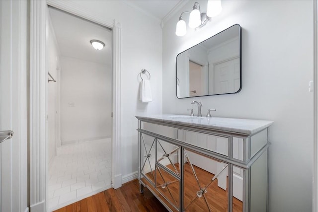 bathroom with crown molding, wood finished floors, and vanity