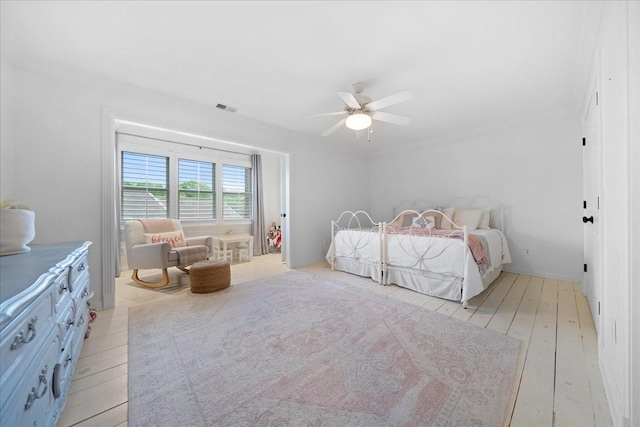 bedroom with visible vents, a ceiling fan, and light wood-type flooring
