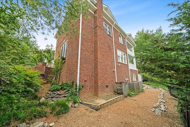 view of home's exterior with a chimney and brick siding
