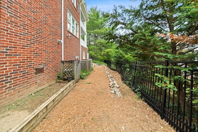 view of property exterior featuring brick siding, fence, and central AC unit
