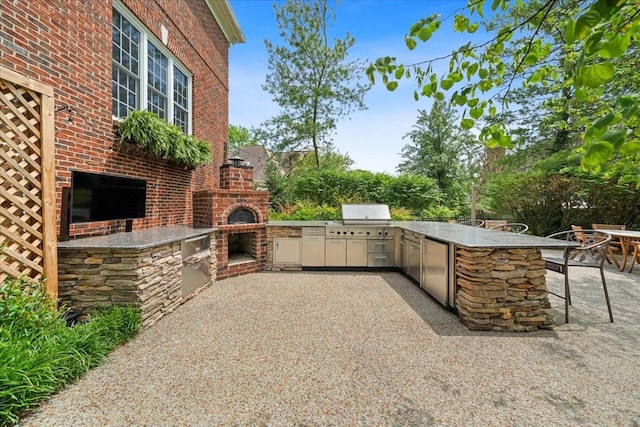 view of patio / terrace featuring exterior kitchen, a bar, and area for grilling