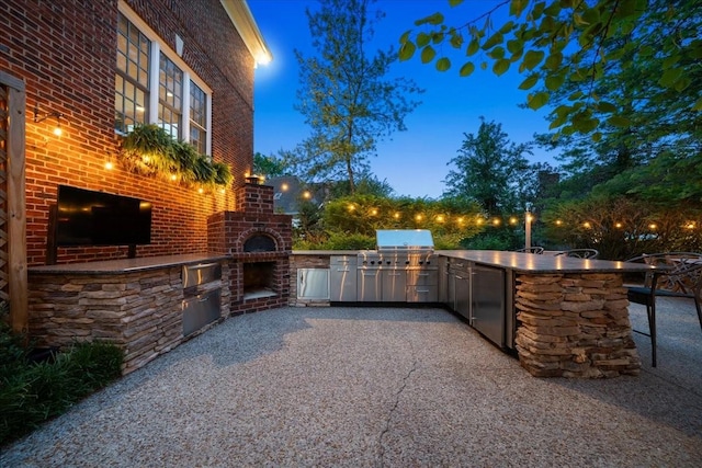 view of patio with grilling area, an outdoor kitchen, and a bar