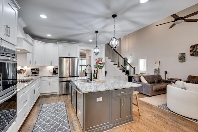 2965 Stewart Campbell Pt, Spring Hill, TN 37174 - kitchen featuring a sink, stainless steel appliances, a ceiling fan, open floor plan, and light wood-type flooring