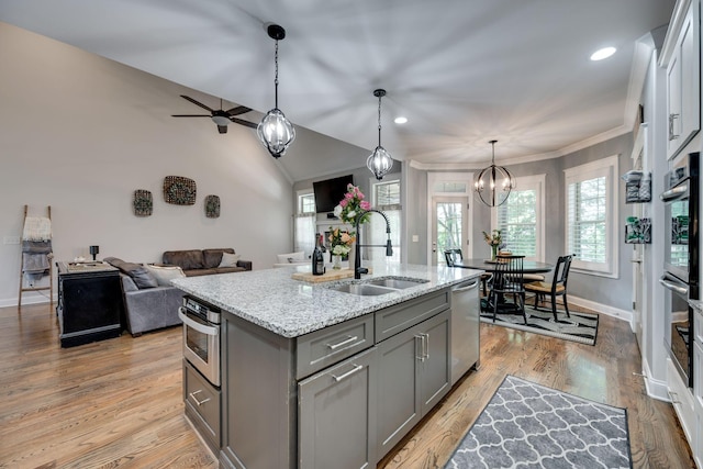 2965 Stewart Campbell Pt, Spring Hill, TN 37174 - kitchen featuring light stone countertops, a sink, an island with sink, stainless steel appliances, and gray cabinetry