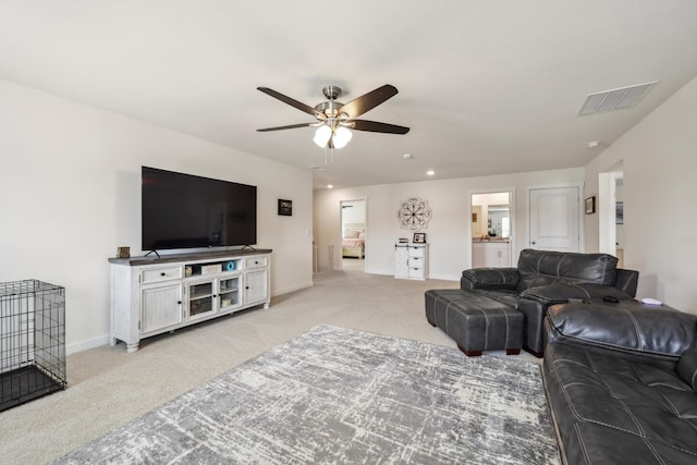 living room featuring visible vents, baseboards, ceiling fan, and light carpet