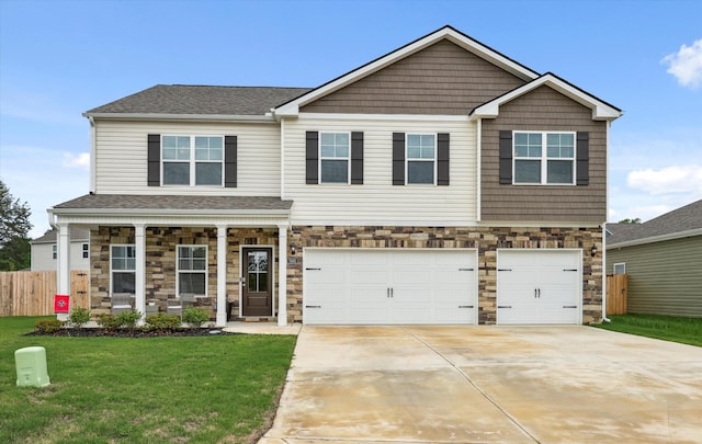 craftsman-style home with a front lawn, fence, stone siding, an attached garage, and driveway