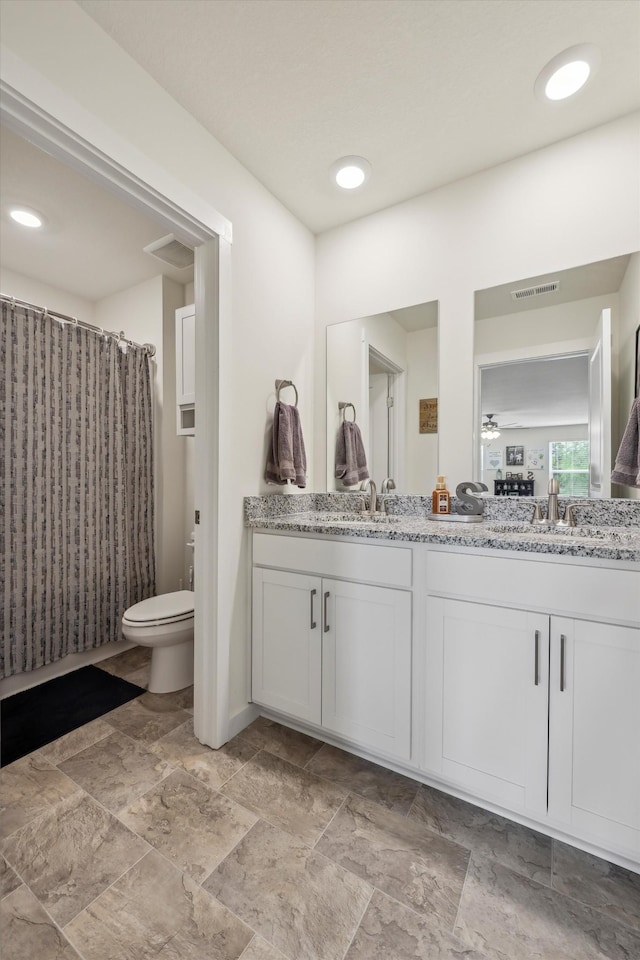 full bathroom featuring visible vents, a sink, double vanity, and toilet