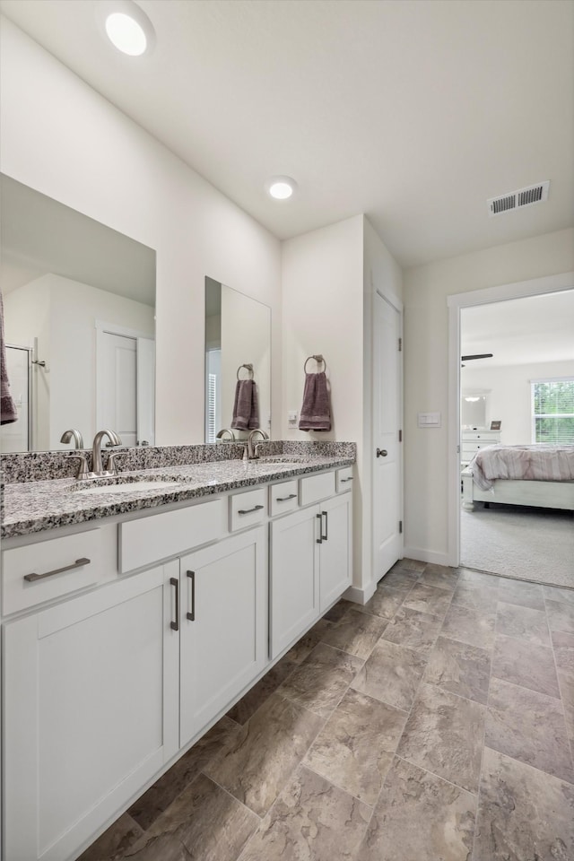 full bath featuring visible vents, double vanity, baseboards, ensuite bathroom, and a sink