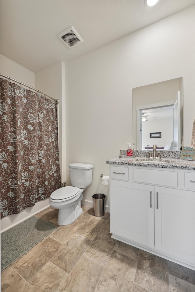 bathroom with visible vents, stone finish floor, toilet, and vanity