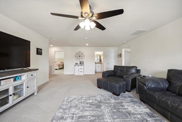 living room with baseboards, ceiling fan, light carpet, and visible vents