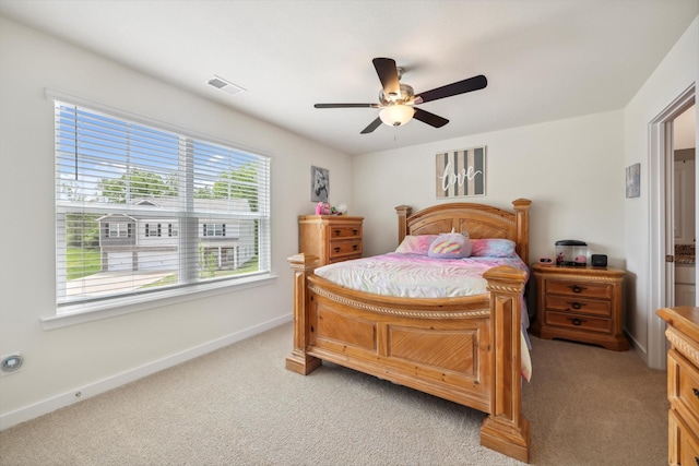 bedroom with baseboards, visible vents, a ceiling fan, and light colored carpet
