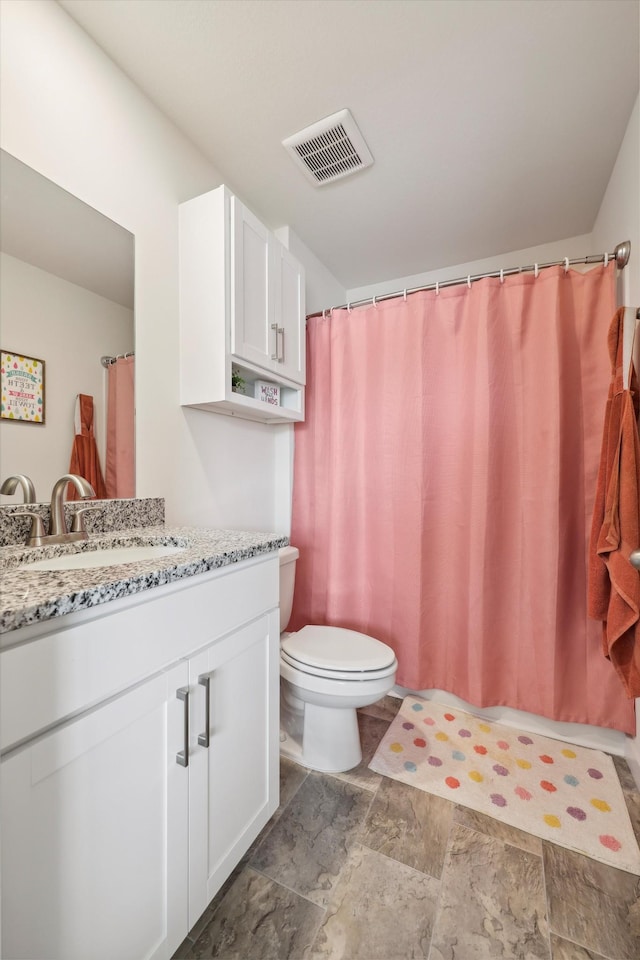 bathroom featuring toilet, visible vents, and vanity