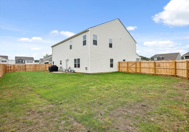 back of property featuring a lawn, a patio, and a fenced backyard