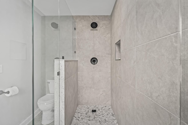 bathroom featuring toilet and tiled shower