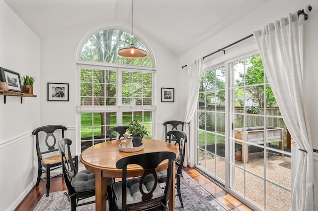 dining room featuring baseboards, wood finished floors, and lofted ceiling