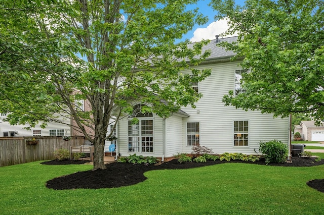 back of house featuring a yard, fence, a shingled roof, and cooling unit