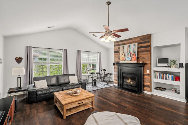 living area with visible vents, a glass covered fireplace, hardwood / wood-style floors, ceiling fan, and vaulted ceiling