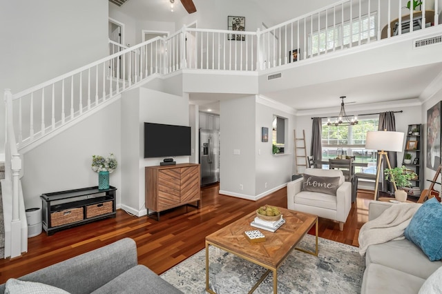 living area featuring visible vents, wood finished floors, and stairway